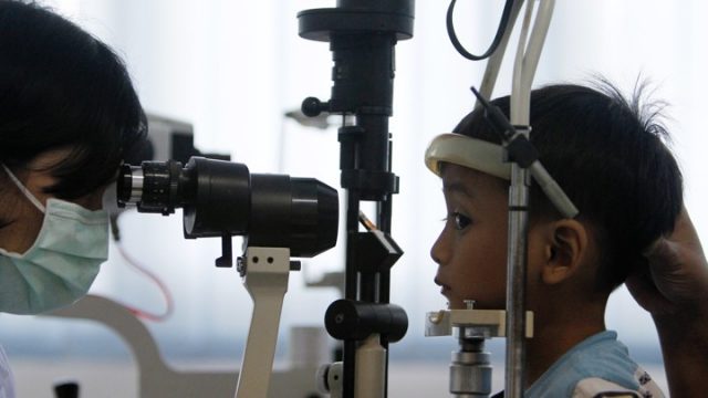 A doctor checks the eyes of a child at the Tambora community health centre in Jakarta